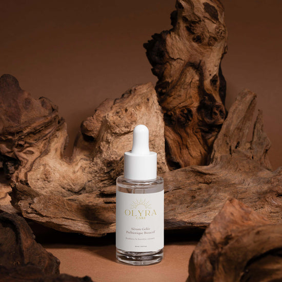 Sérum Gelée Prébiotiques – Olyra Care sur un fond de bois naturel, mettant en valeur l’éclat et l’hydratation de la peau.