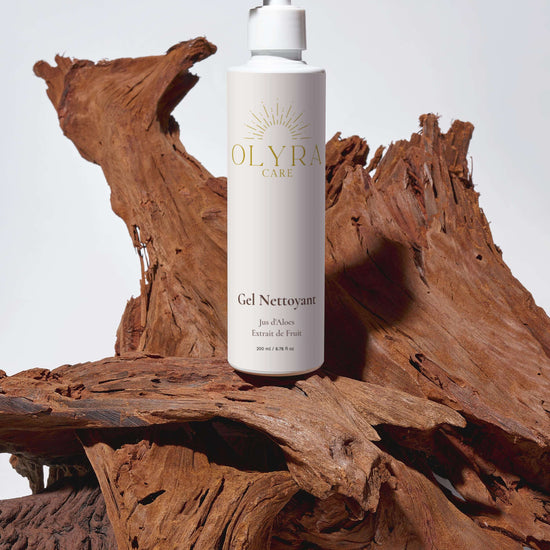 Gel nettoyant visage Olyra Care sur un fond en bois naturel, pour une pureté et fraîcheur optimales.