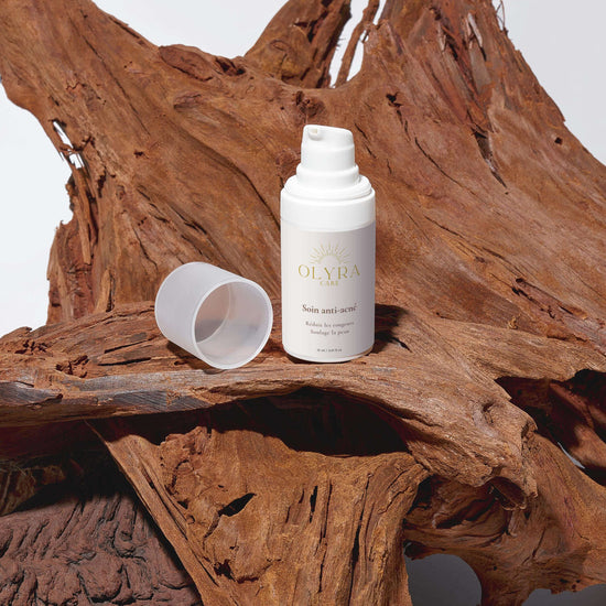 Soin Anti-Acné Olyra Care sur une surface en bois, flacon avec bouchon ouvert pour un effet purifiant.